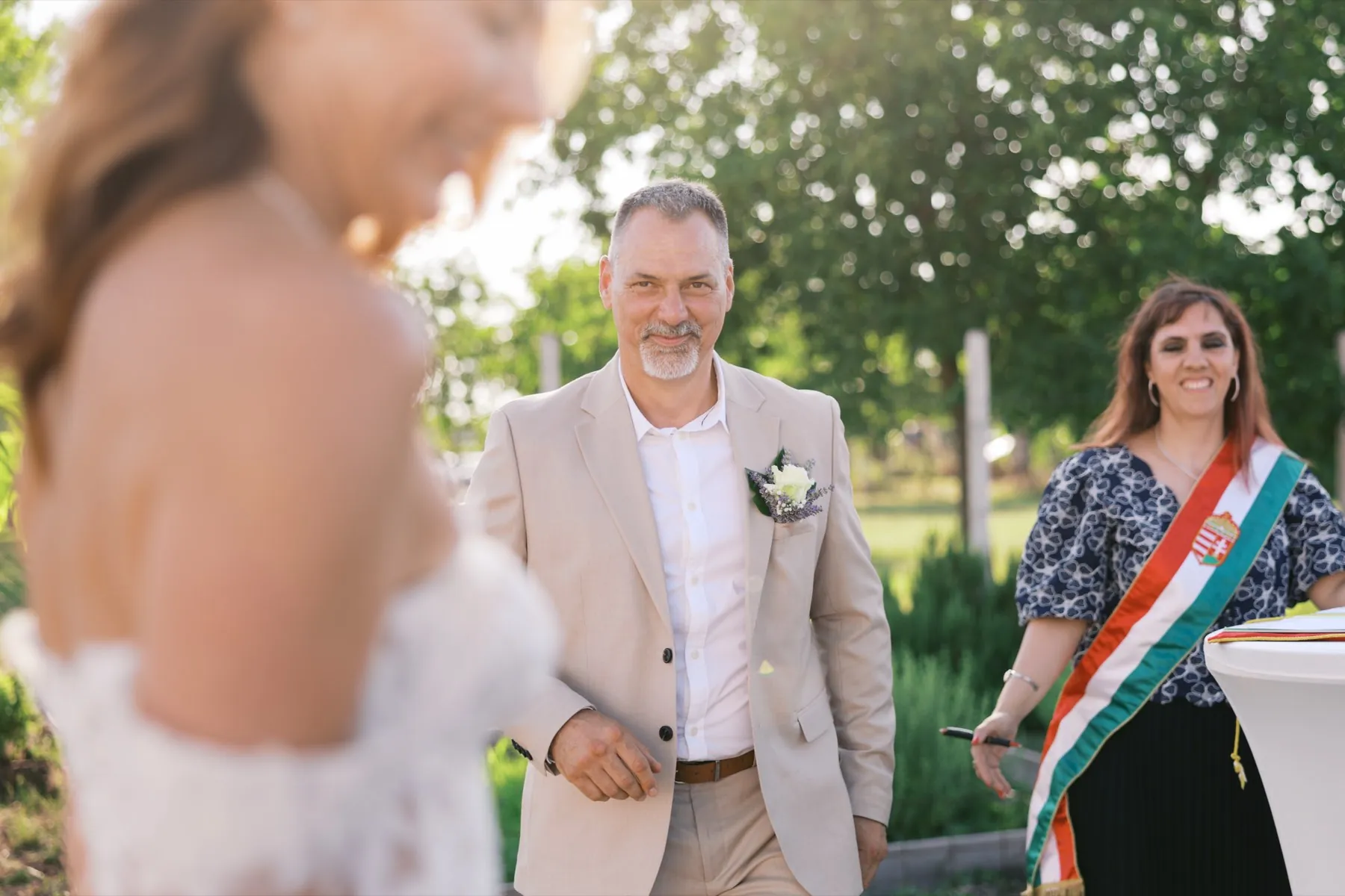 Vőlegény a szertartásra vezető úton, világos öltönyben